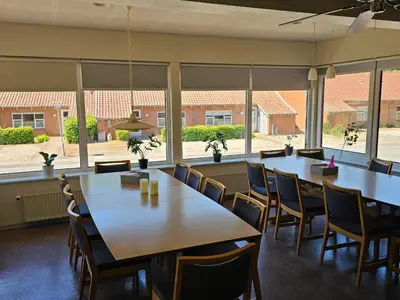 a room with tables and chairs and large windows at Cozy Danish Room for Solo Stays in Lemvig