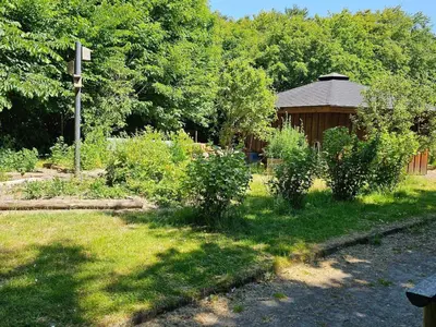 a garden with a gazebo and some bushes at Cozy Danish Room for Solo Stays in Lemvig