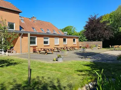 a group of tables and benches in front of a building at Cozy Danish Room for Solo Stays in Lemvig