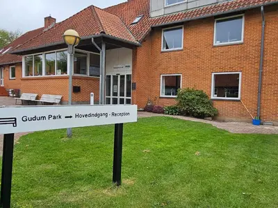a sign in the grass in front of a house at Compact standard single room in Lemvig in Lemvig