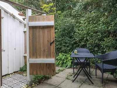 a table and chairs next to a wooden fence at 4 person holiday home in Struer in Struer
