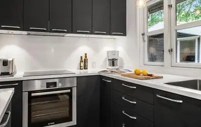 a kitchen with black cabinets and a counter with fruit on a cutting board at Amazing Home In Roslev With Wifi in Roslev