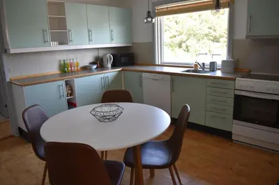 a kitchen with a white table and chairs and a table at Viking Surf Home in Klitmøller