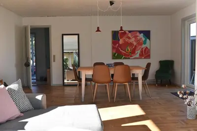 a living room with a dining room table and chairs at Viking Surf Home in Klitmøller
