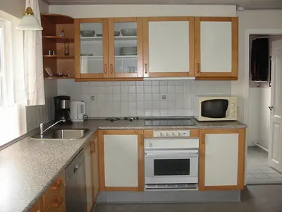 a kitchen with a stove and a microwave at Holiday Home Kirkeby Feriehus in Roslev