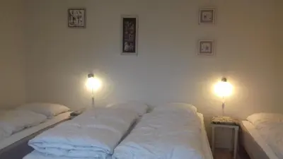a bedroom with two beds with lights on the wall at Holiday Home Kirkeby Feriehus in Roslev