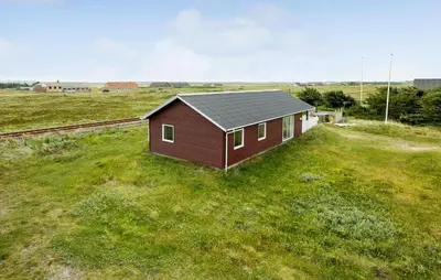 a small red house in a field of grass at Awesome Home In Harboøre in Harboør