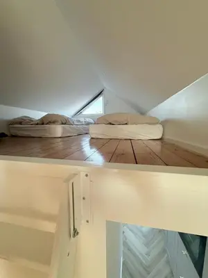 two beds sitting on a wooden floor in a room at Cozy harbor house in Nibe in Nibe
