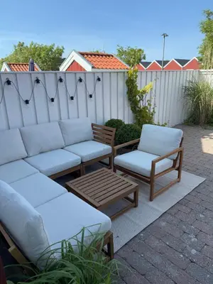 a patio with a couch and chairs and a fence at Cozy harbor house in Nibe in Nibe