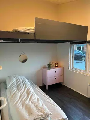 a bedroom with a bunk bed and a dresser and a window at Sjarmerende og hyggelig lite hjem in Holstebro