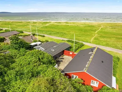 an aerial view of a red house with the ocean in the background at Holiday Home Blia - 120m to the fjord by Interhome in Løgstør