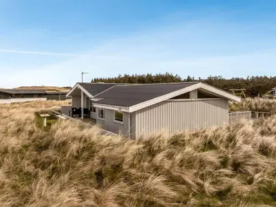 a house sitting on top of a field of grass at Holiday Home Fridgerd - 300m from the sea by Interhome in Løkken
