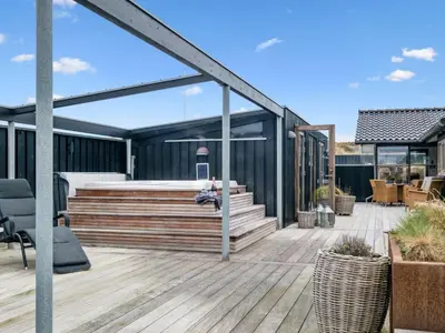 a deck with a bed on a house at Holiday Home Sinika - 100m from the sea by Interhome in Blokhus