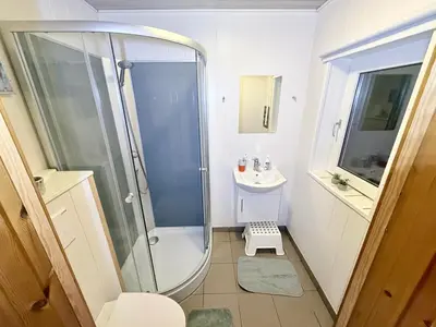 a small bathroom with a shower and a sink at Amtoft Vig Kitespot in Vesløs