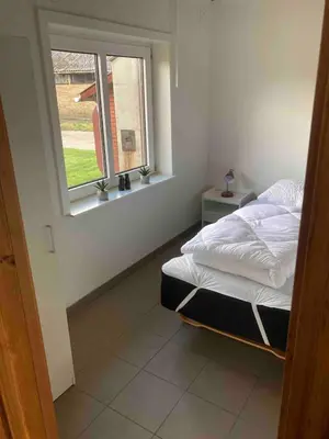 a bedroom with a bed and a window at Amtoft Vig Kitespot in Vesløs