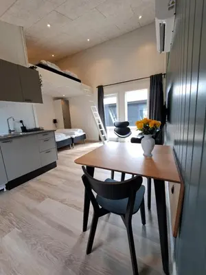 a kitchen and living room with a wooden table and chairs at Motel Glyngøre in Roslev