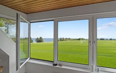 a room with windows looking out at a green field at Stunning Home In Nykøbing M With Sauna in Alsted