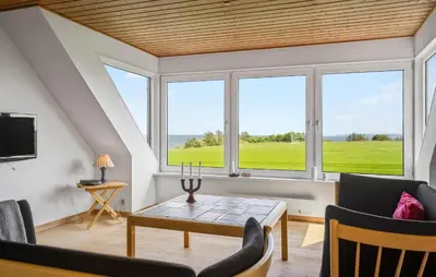 a living room with a table and chairs and windows at Stunning Home In Nykøbing M With Sauna in Alsted
