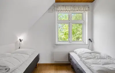 two beds in a white room with a window at Stunning Home In Nykøbing M With Sauna in Alsted