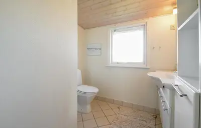 a bathroom with a toilet and a sink and a window at 2 Bedroom Pet Friendly Home In Thisted in Thisted