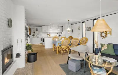 a living room with a table and chairs and a fireplace at 3 Bedroom Nice Home In Harboøre in Harboør