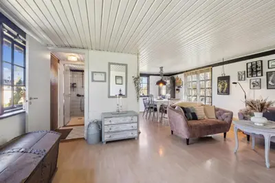 a living room with a couch and a table at Astrup Vig Hideaway, Thatched Cottage with Shelter & Serenity in Roslev