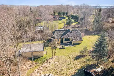 an aerial view of a house in the woods at Astrup Vig Hideaway, Thatched Cottage with Shelter & Serenity in Roslev