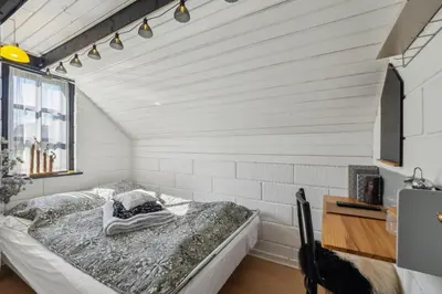 a bedroom with a bed in a room with white walls at Astrup Vig Hideaway, Thatched Cottage with Shelter & Serenity in Roslev