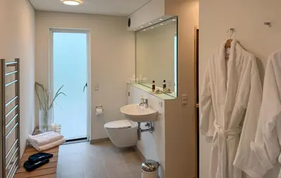 a bathroom with a sink and a toilet and a mirror at Cozy Home In Vestervig With Sauna in Vestervig
