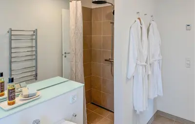 a white bathroom with a shower and a sink at Cozy Home In Vestervig With Sauna in Vestervig