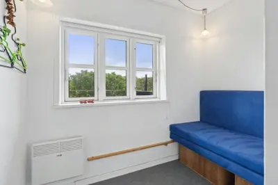a blue couch in a room with a window at Thatched Holiday Home By The North Sea In Blokhus in Blokhus