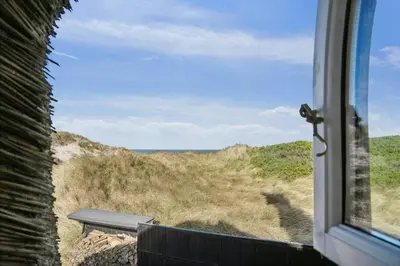 a view of the ocean from a train window at Thatched Holiday Home By The North Sea In Blokhus in Blokhus
