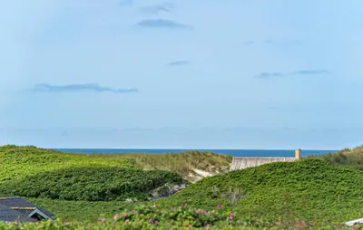 a house on a hill with the ocean in the background at Gorgeous Home In Lemvig in Lemvig