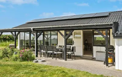 a house with a conservatory with a table and chairs at Gorgeous Home In Lemvig in Lemvig