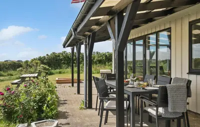 a patio with a table and chairs and some flowers at Gorgeous Home In Lemvig in Lemvig