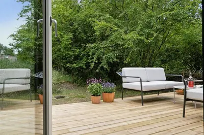 a patio with two chairs on a wooden deck at Architect-Designed Wooden House At Ertebølle in Farsø