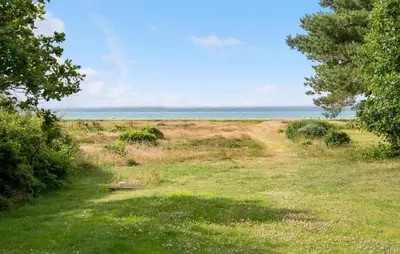 a grassy field with the ocean in the background at Stunning Home In Hurup Thy With Wifi in Sønder Ydby