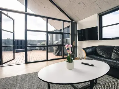 a living room with a table and a couch at 5 star holiday home in Løkken in Løkken