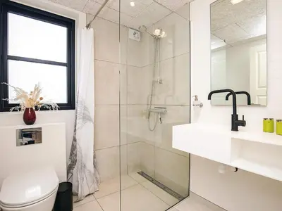 a bathroom with a shower and a toilet and a sink at 5 star holiday home in Løkken in Løkken