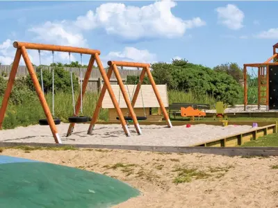 a playground with two swings in the sand at 4 star holiday home in Thyborøn in Thyborøn