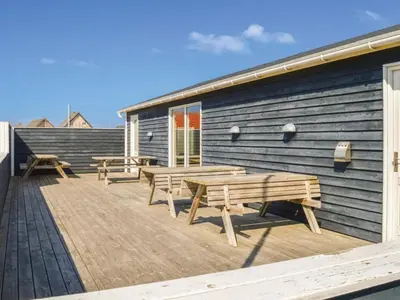a deck with benches on the side of a building at 4 star holiday home in Thyborøn in Thyborøn