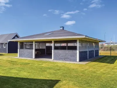 a house with a porch and a grass field at 4 star holiday home in Thyborøn in Thyborøn