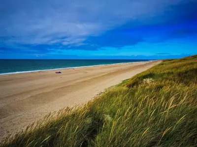 a sandy beach with the ocean in the background at 4 star holiday home in Harboøre in Harboør
