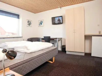 a bedroom with a bed and a desk with a computer at 5 star holiday home in Thyborøn in Thyborøn