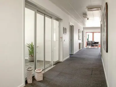 an office corridor with glass doors and a hallway with a plant at 5 star holiday home in Thyborøn in Thyborøn