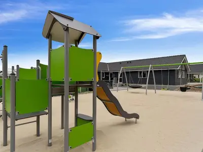 a playground with a slide in front of a building at 5 star holiday home in Spøttrup in Spottrup