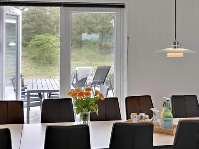 a dining room with a table and chairs and a large window at 5 star holiday home in Spøttrup in Spottrup