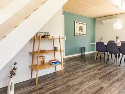 a living room with a table and chairs and a staircase at 5 star holiday home in Farsø in Farsø