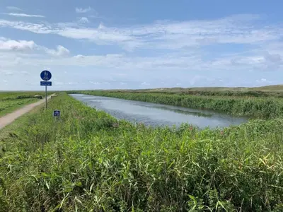 a road next to a river with a sign on it at 4 star holiday home in Thyborøn in Thyborøn