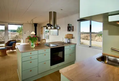 a kitchen with white cabinets and a counter top at Holiday Home Overlooking Protected Dune Heath in Frøstrup